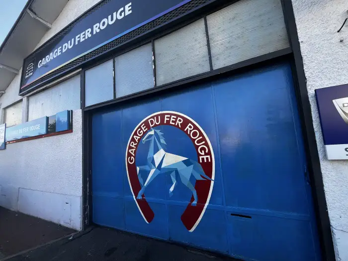 Porte du garage peinte aux couleurs du Garage du Fer Rouge